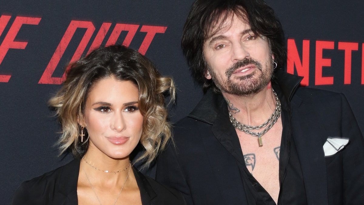 Brittany Furlan and Tommy Lee looking serious at the red carpet premiere of his movie "The Dirt."