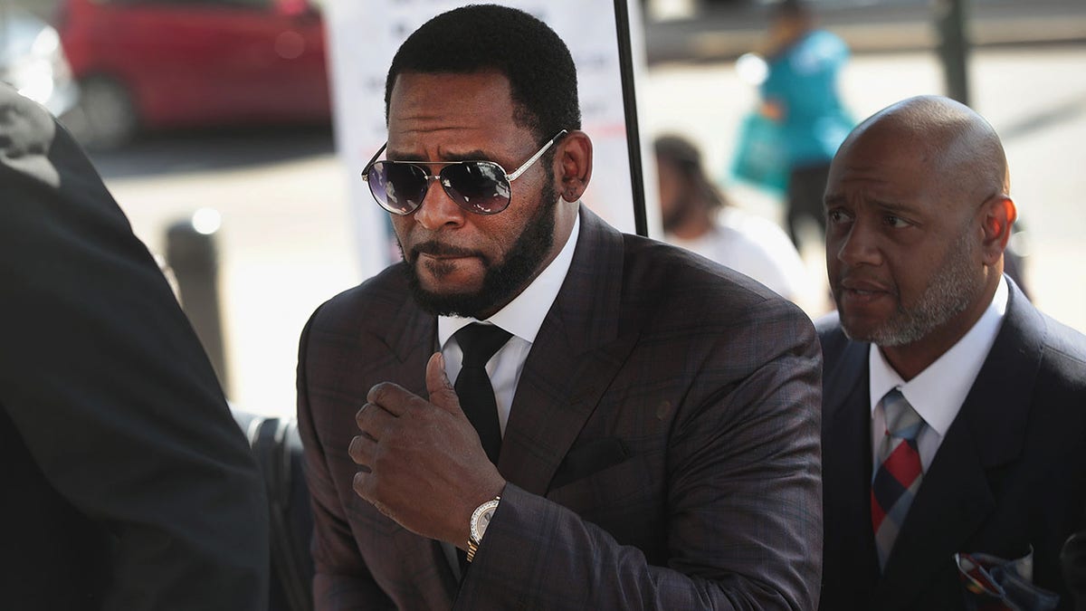 A somber looking R. Kelly in a dark plaid suit appears at court in Chicago
