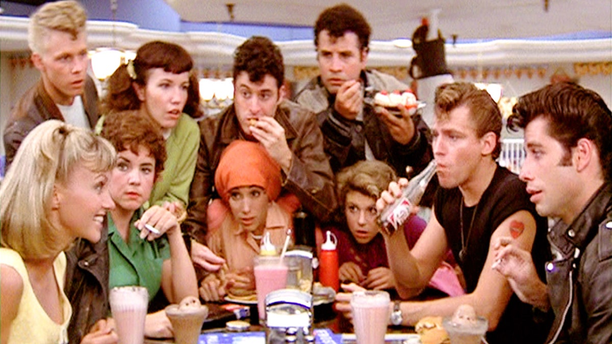 The cast of Grease in a scene at the diner