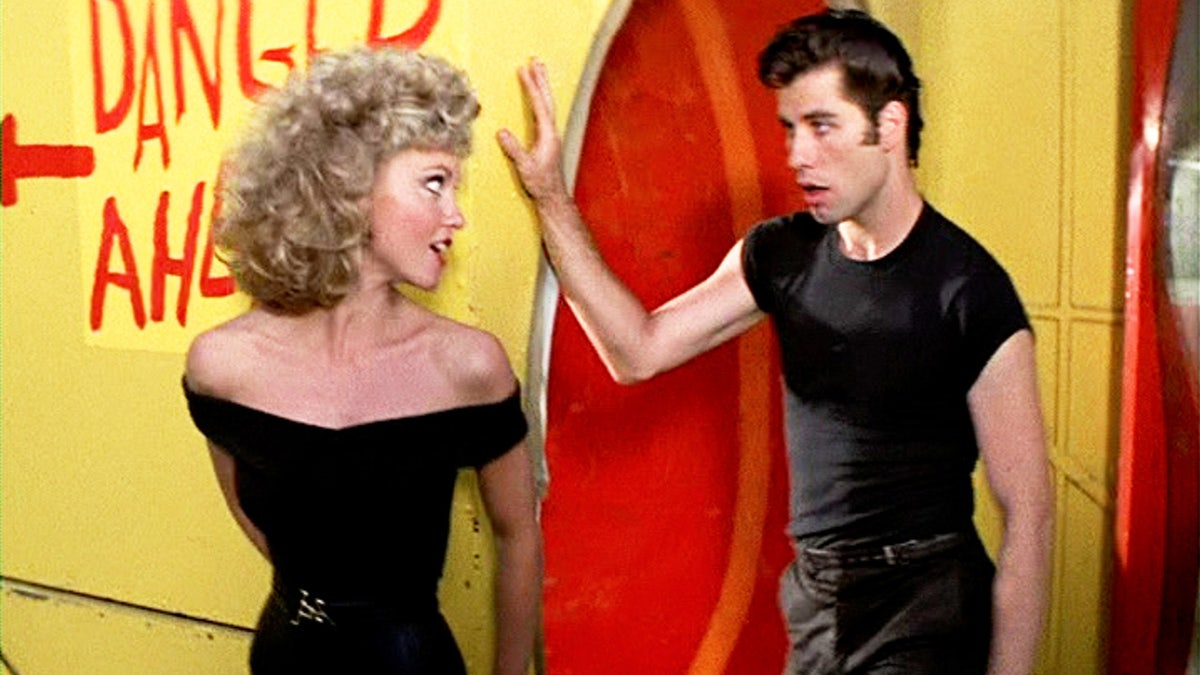 John Travolta and Olivia Newton John singing while filming "Grease"