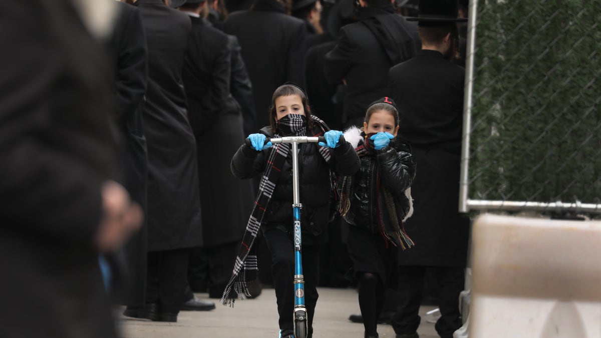 Orthodox child rides scooter.