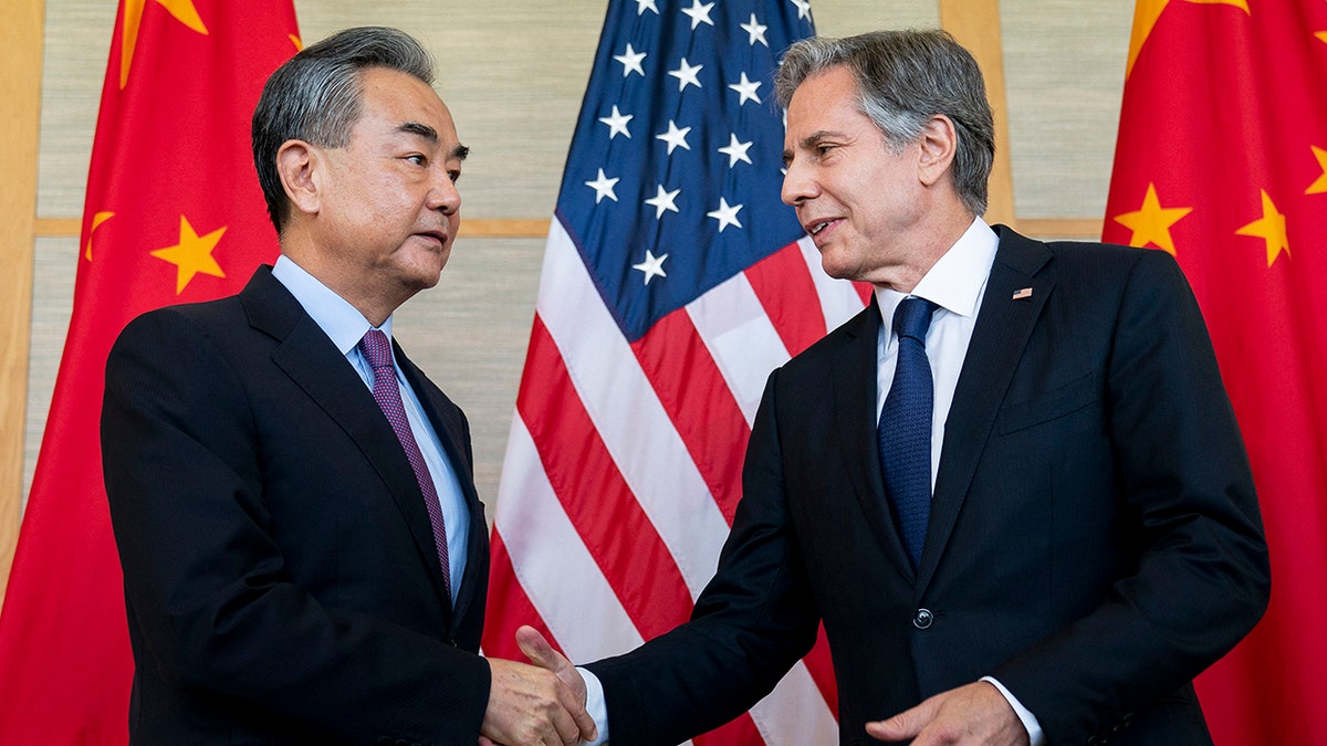 Wang Yi and Antony Blinken shake hands