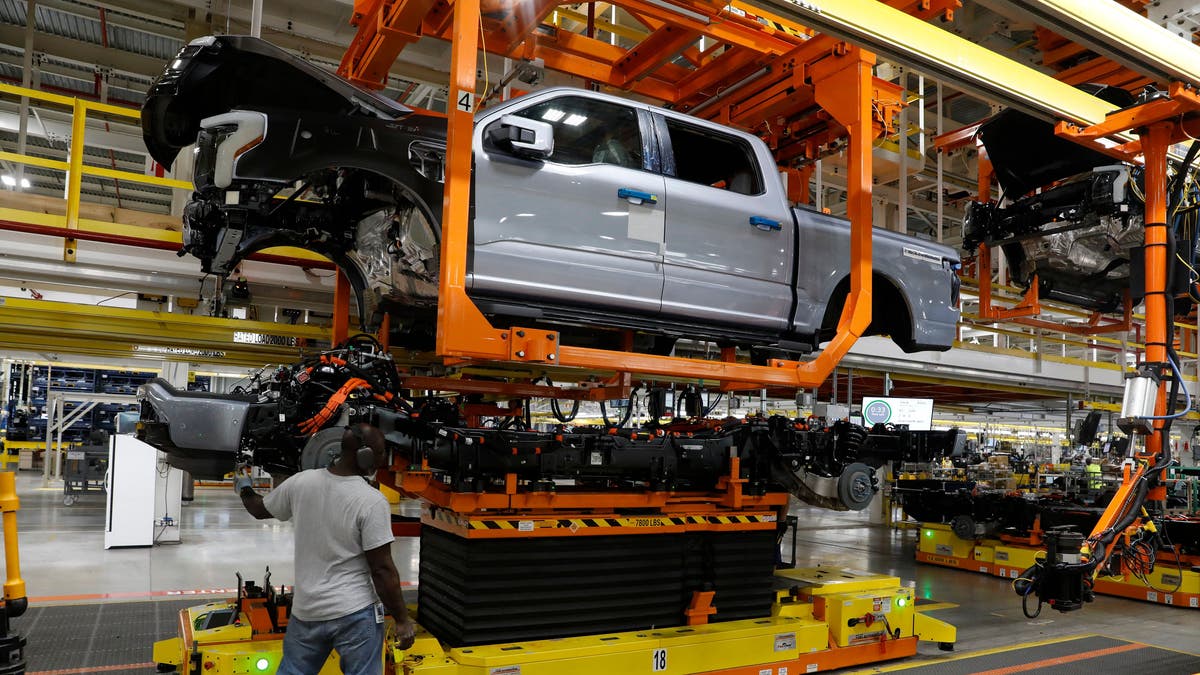 The truck cab is lowered on the frame of Ford Motor Co. battery powered F-150 Lightning trucks under production at their Rouge Electric Vehicle Center in Dearborn, Michigan on September 20, 2022. - Construction crews are back at Dearborn, remaking Ford's century-old industrial complex once again, this time for a post-petroleum era that is finally beginning to feel possible. The manufacturing operation's prime mission in recent times has been to assemble the best-selling F-150, a gasoline-powered vehicle (Photo by JEFF KOWALSKY / AFP) (Photo by JEFF KOWALSKY/AFP via Getty Images)