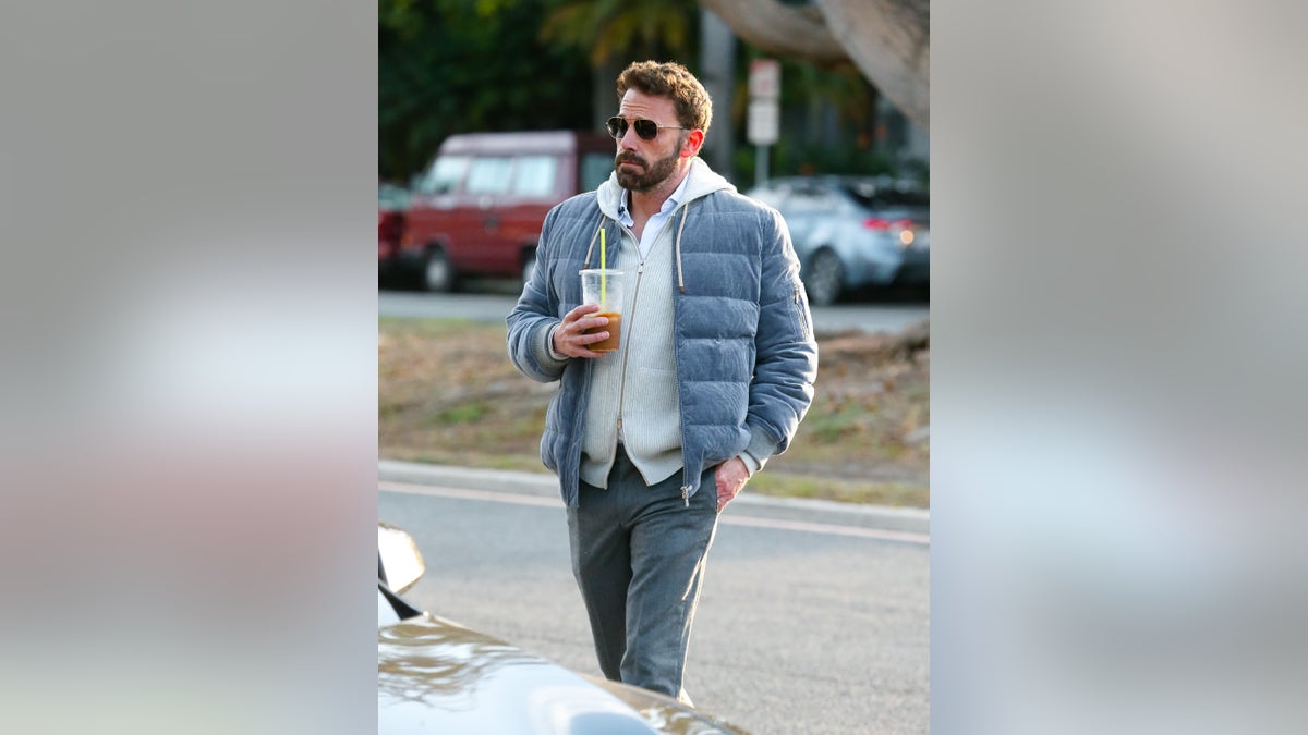 Ben Affleck in grey jacket holding iced coffee