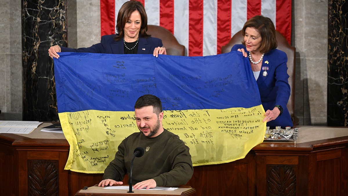 Kamala Harris and Nancy Pelosi holding the Ukrainian flag