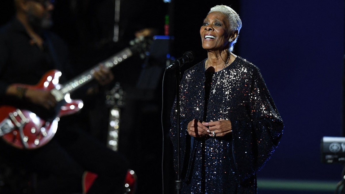 Dionne Warwick sings on stage wearing an ombre sequined dress at the MusiCares Persons of the Year event