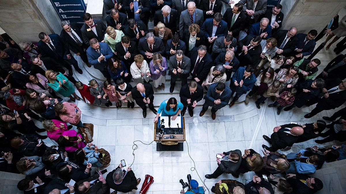 Sarah Sanders surrounded by officials