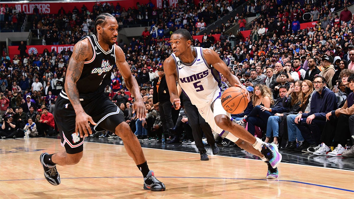 De'Aaron Fox drives against Kawhi Leonard