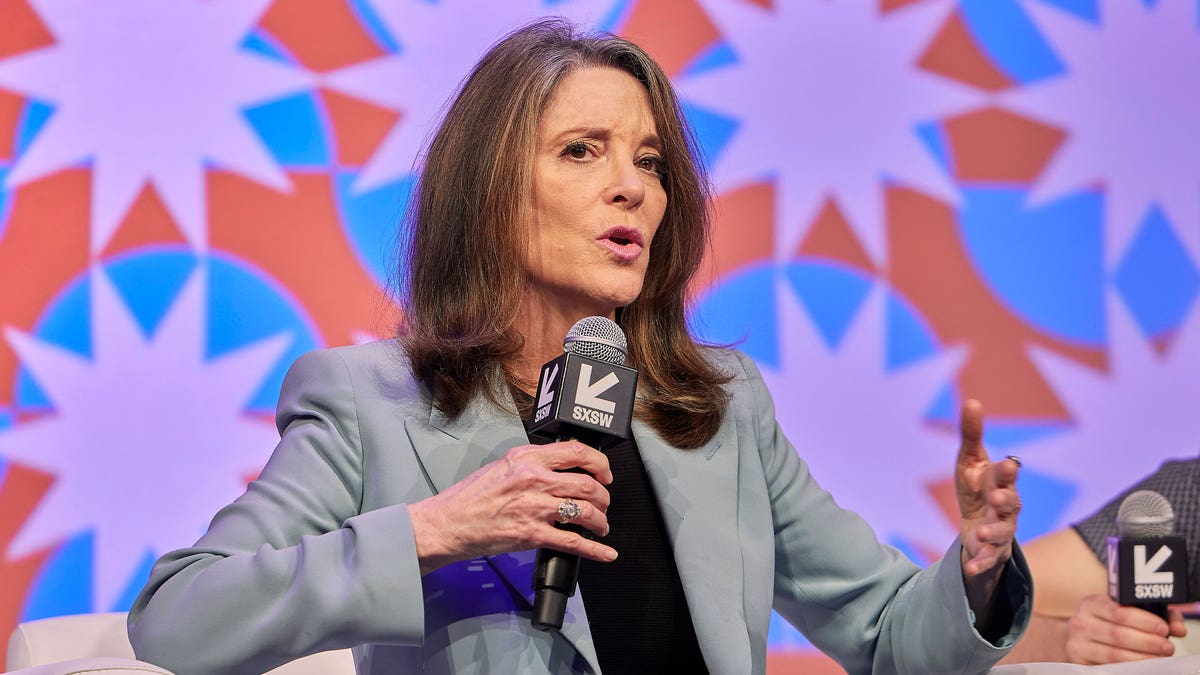 Marianne Williamson holding microphone