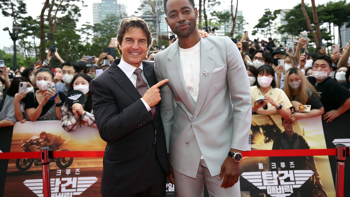 Tom cruise stands next to Jay Ellis