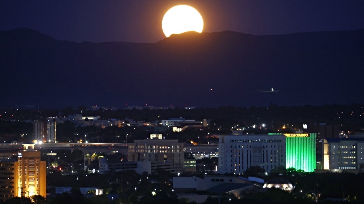 The Sturgeon Moon rises beyond the city on August 11, 2022 in Albuquerque, New Mexico. The Sturgeon Moon is the fourth and final super moon of 2022.
