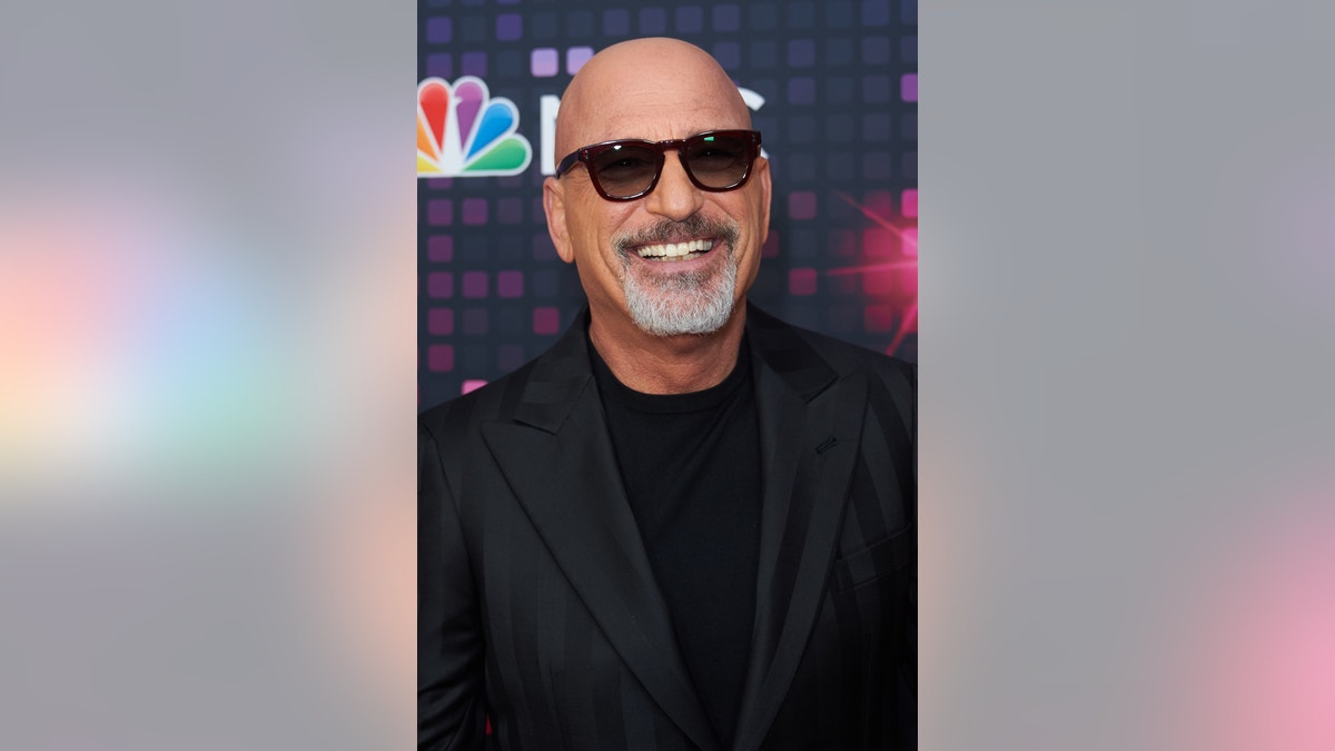 Howie Mandel smiling and wearing sunglasses on the red carpet