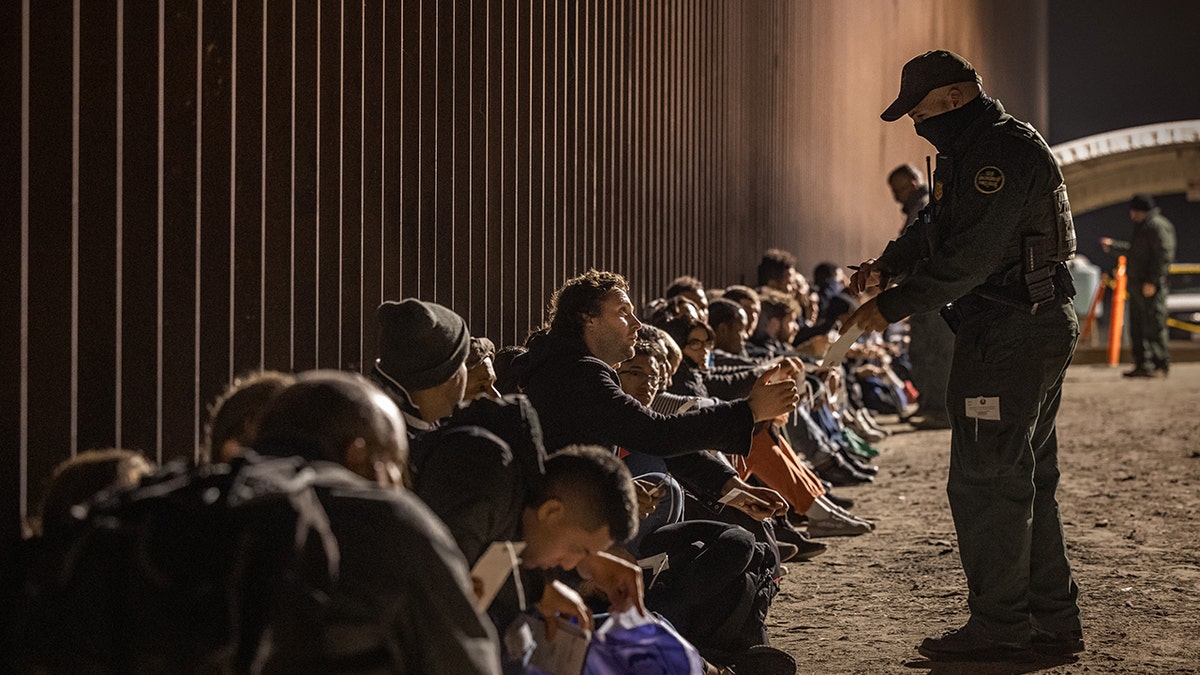 A CBP agent and migrants