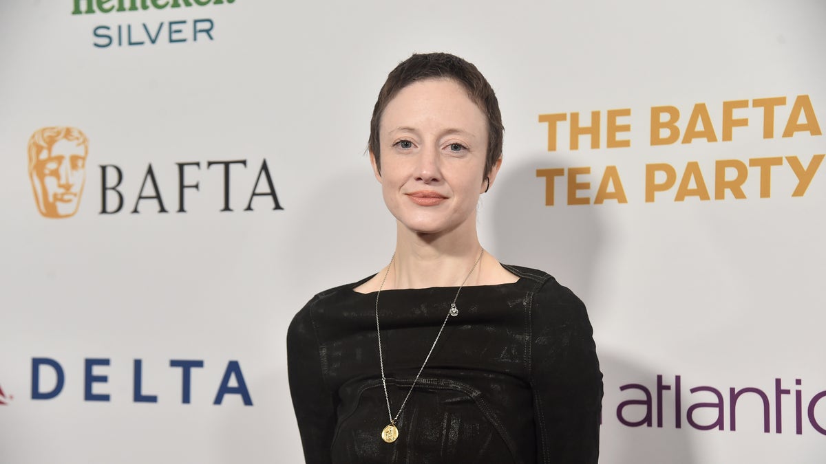 Andrea Riseborough with short hair and a black dress