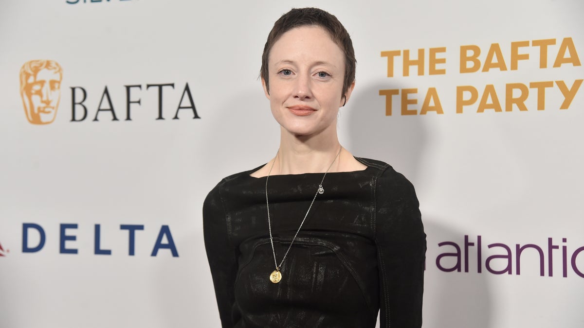 Andrea Riseborough with short hair and a black dress