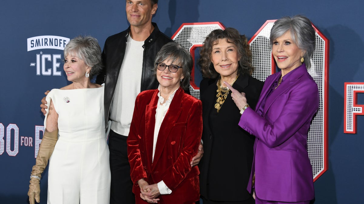 (L-R) Rita Moreno, Tom Brady, Sally Field, Lily Tomlin and Jane Fonda pose together on red carpet at the "80 for Brady" premiere