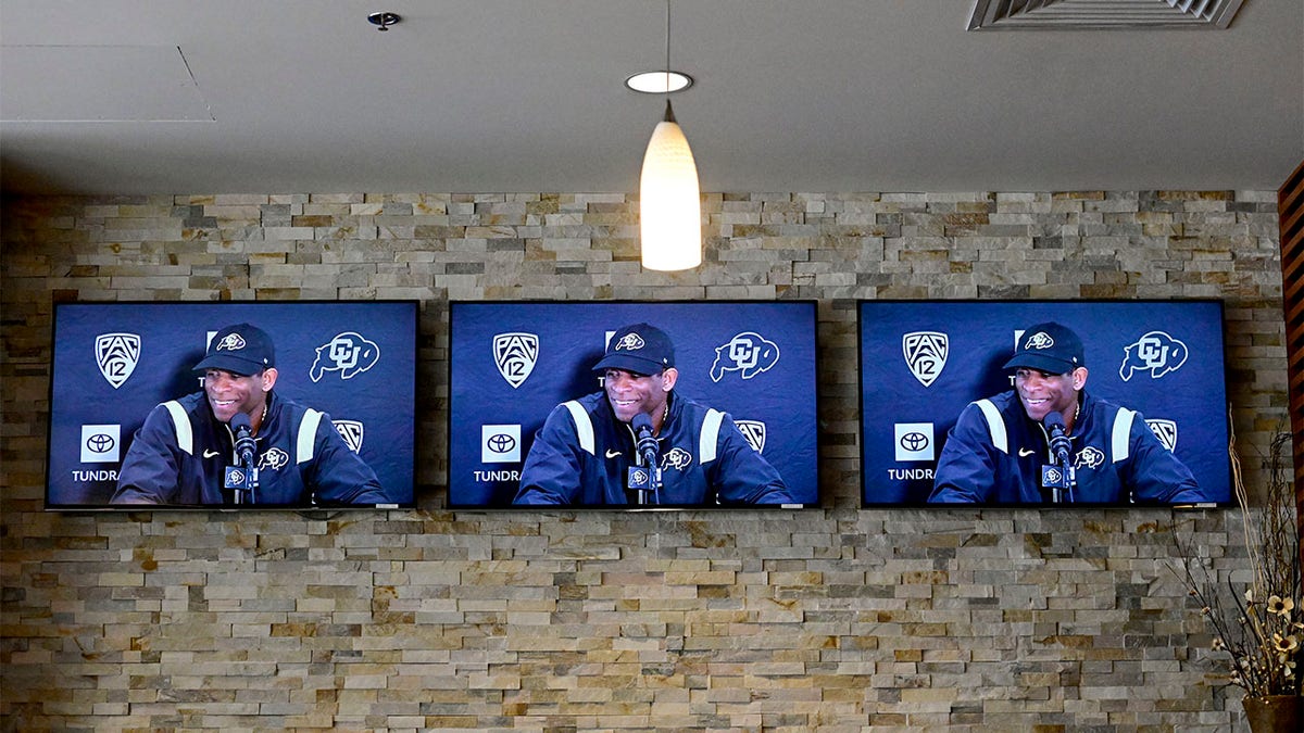 Colorado head coach Deion Sanders speaks with reporters