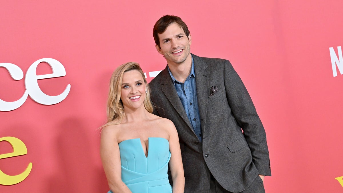 Reese Witherspoon and Ashton Kutcher smile together at the premiere of their movie "Your Place or Mine"