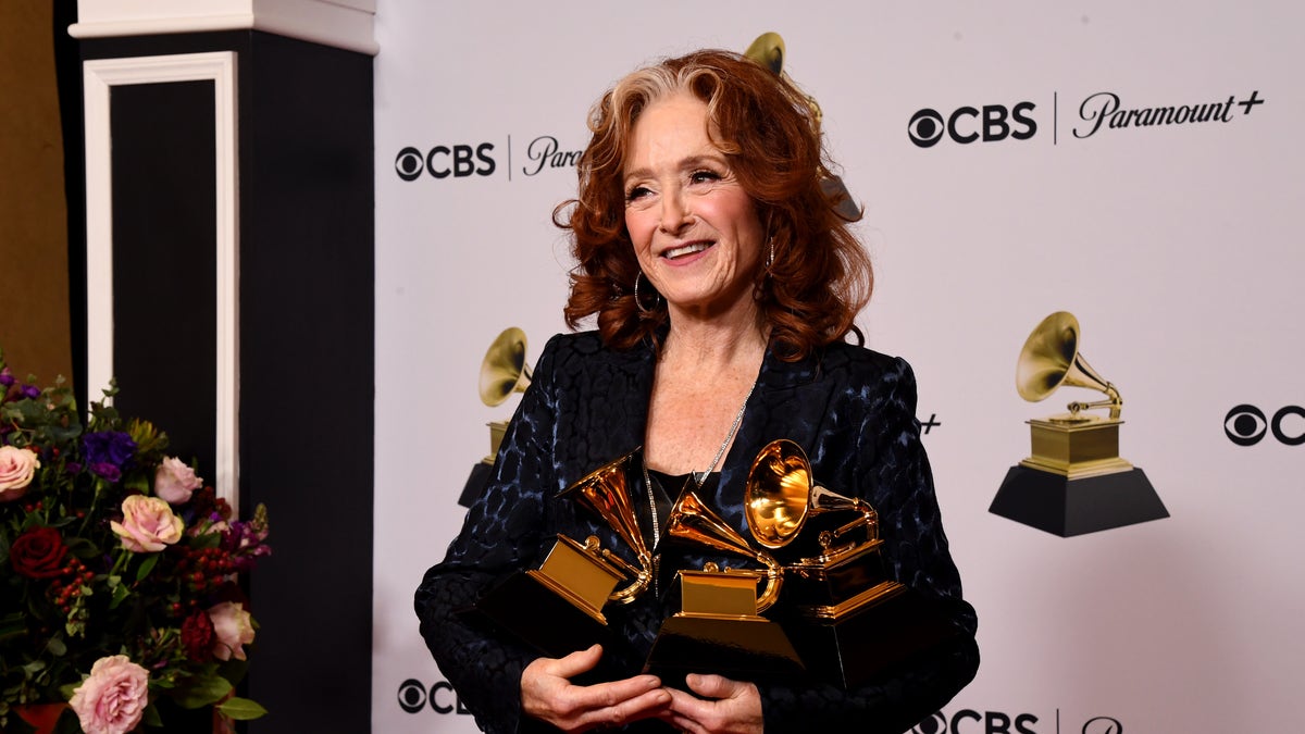Bonnie Raitt holds her three Grammy Awards backstage at the 2023 Grammys