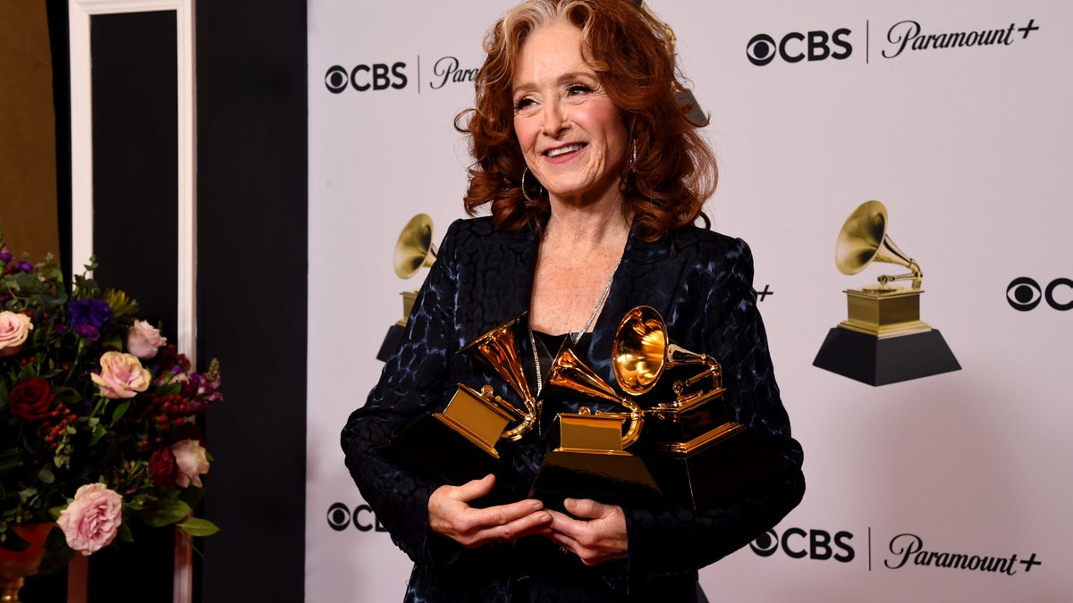 Bonnie Raitt holds her three Grammy Awards backstage at the 2023 Grammys
