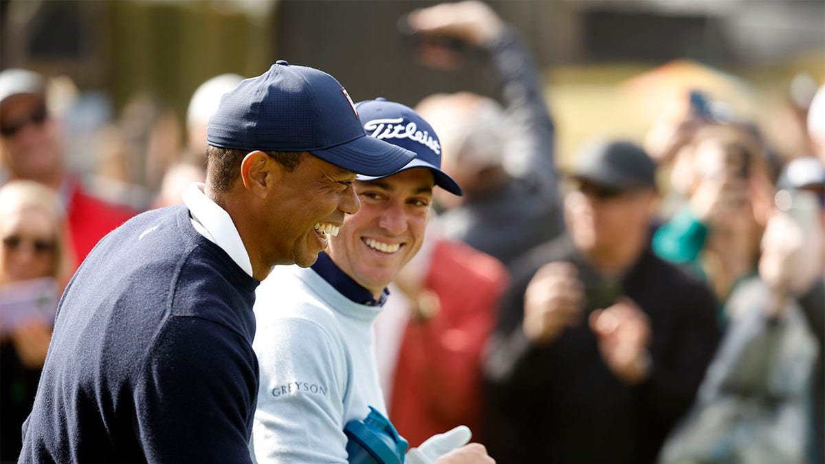 Tiger Woods and Justin Thomas share a laugh on the ninth hole