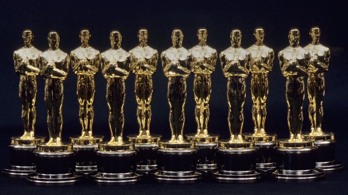 A row of seven Oscar statuettes lined up