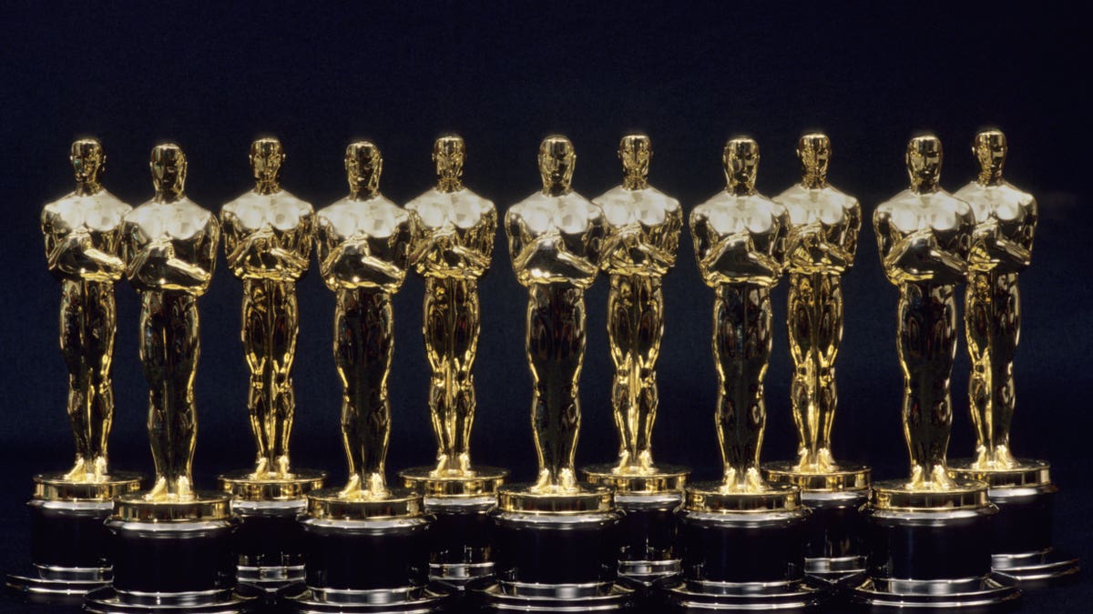 A row of seven Oscar statuettes lined up