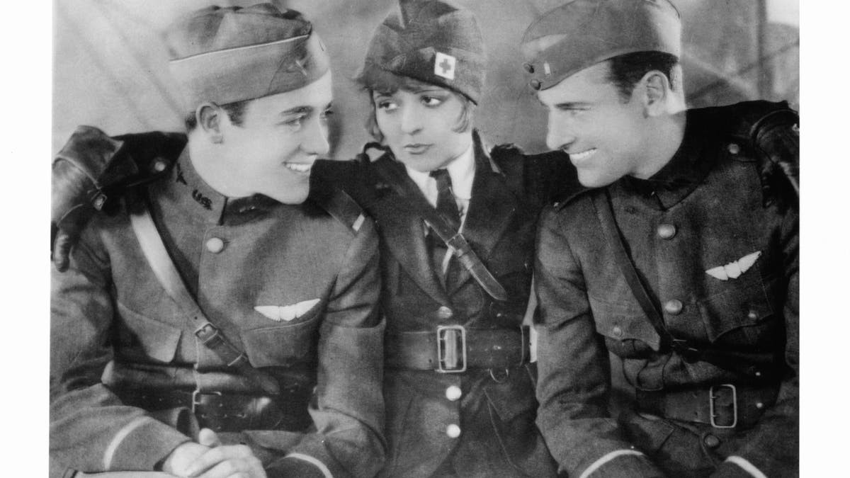 Black and white photo of Charles 'Buddy' Rogers, Clara Bow, and Richard Arlen in costume for movie