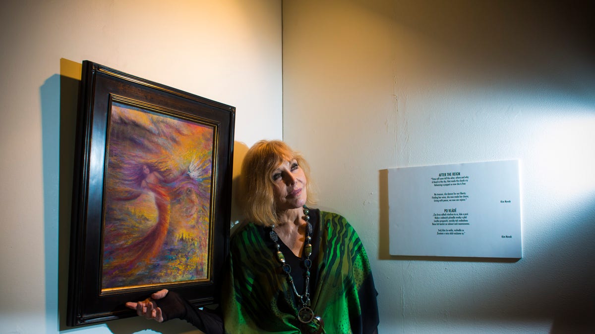 Kim Novak poses with her painting, while wearing green.