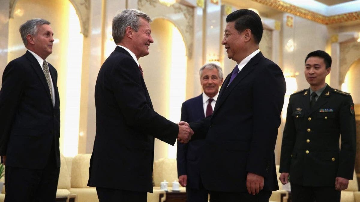 US Ambassador to China Max Baucus shakes hands with Chinese President Xi Jinping.