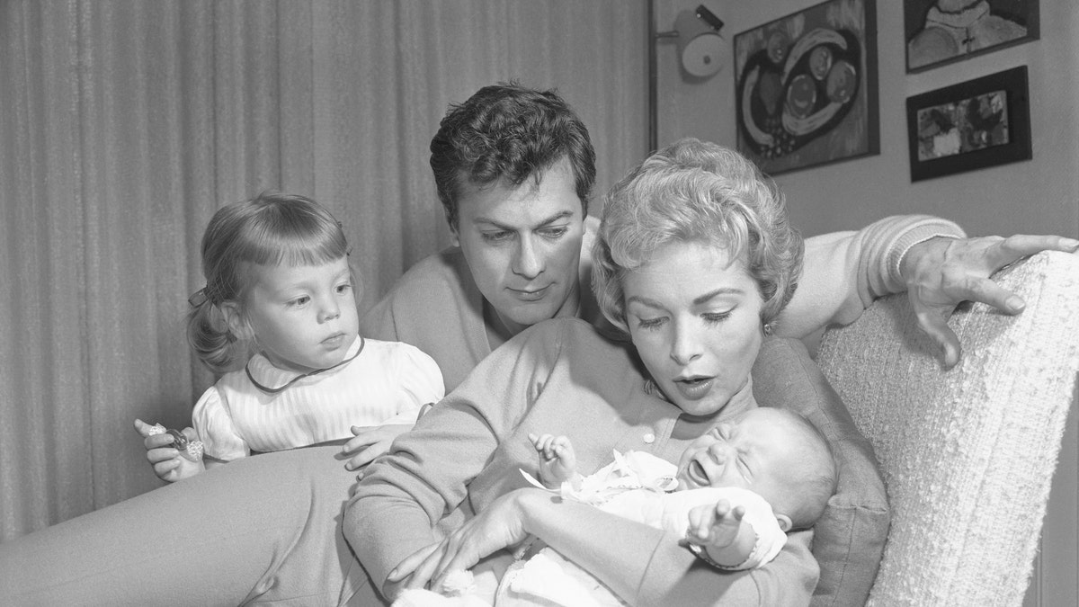 Janet Leigh holding baby Jamie Lee Curtis, as Tony Curtis and Jamie Lee's older sister Kelly look on