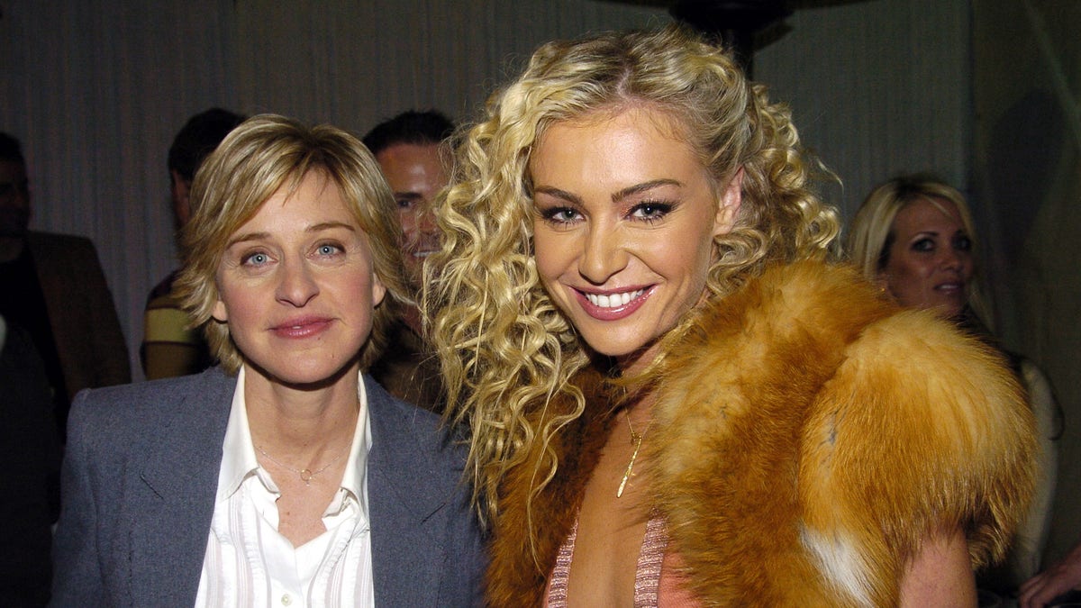 Ellen DeGeneres and Portia de Rossi pose together backstage at an event in 2004