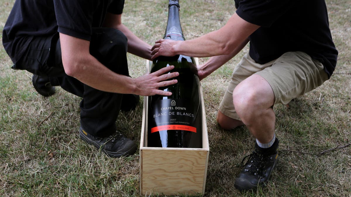 two men lift a15 liter Nebuchadnezzar bottle