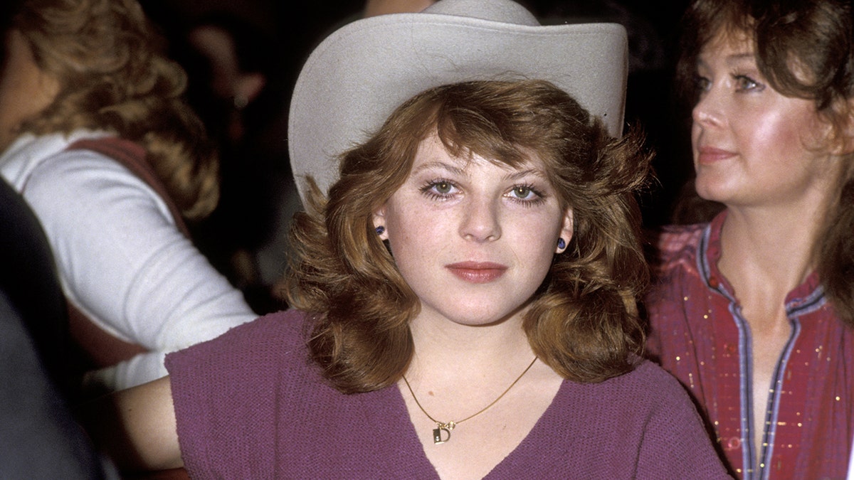 Dawn Lyn wearing a purple shirt and a cowboy hat