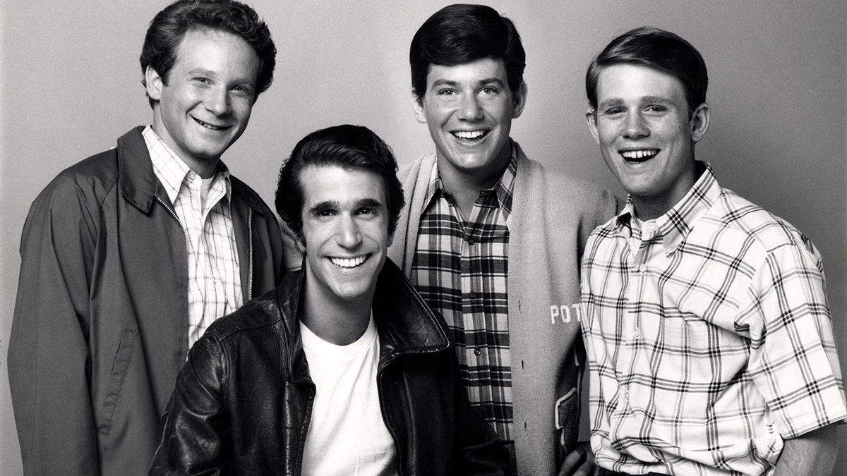 A black and white photo of Don Most, Henry Winkler, Anson Williams and Ron Howard from 'Happy Days'