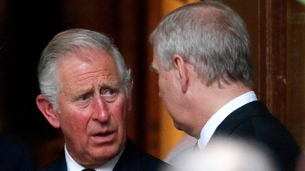 King Charles having a serious conversation with Prince Andrew who is looking away from the camera
