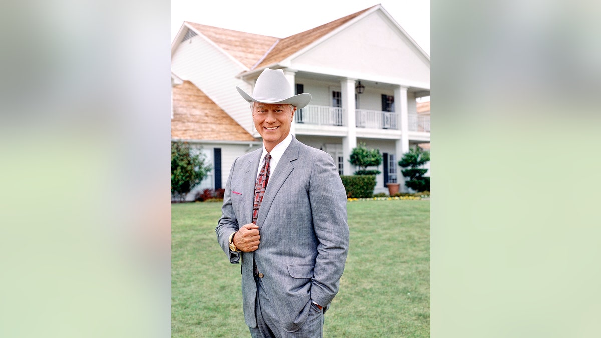 A photo of Larry Hagman smiling in a suit wearing a cowboy hat