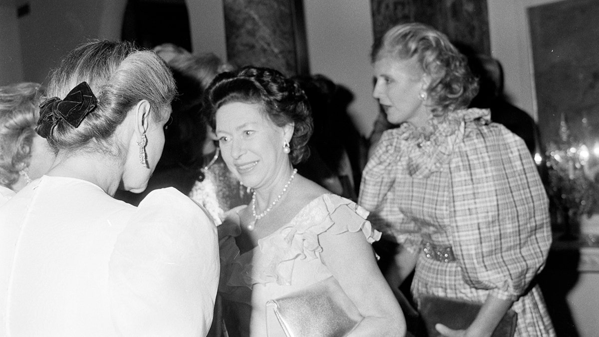 A black and white photo of Princess Margaret greeting a guest at a party