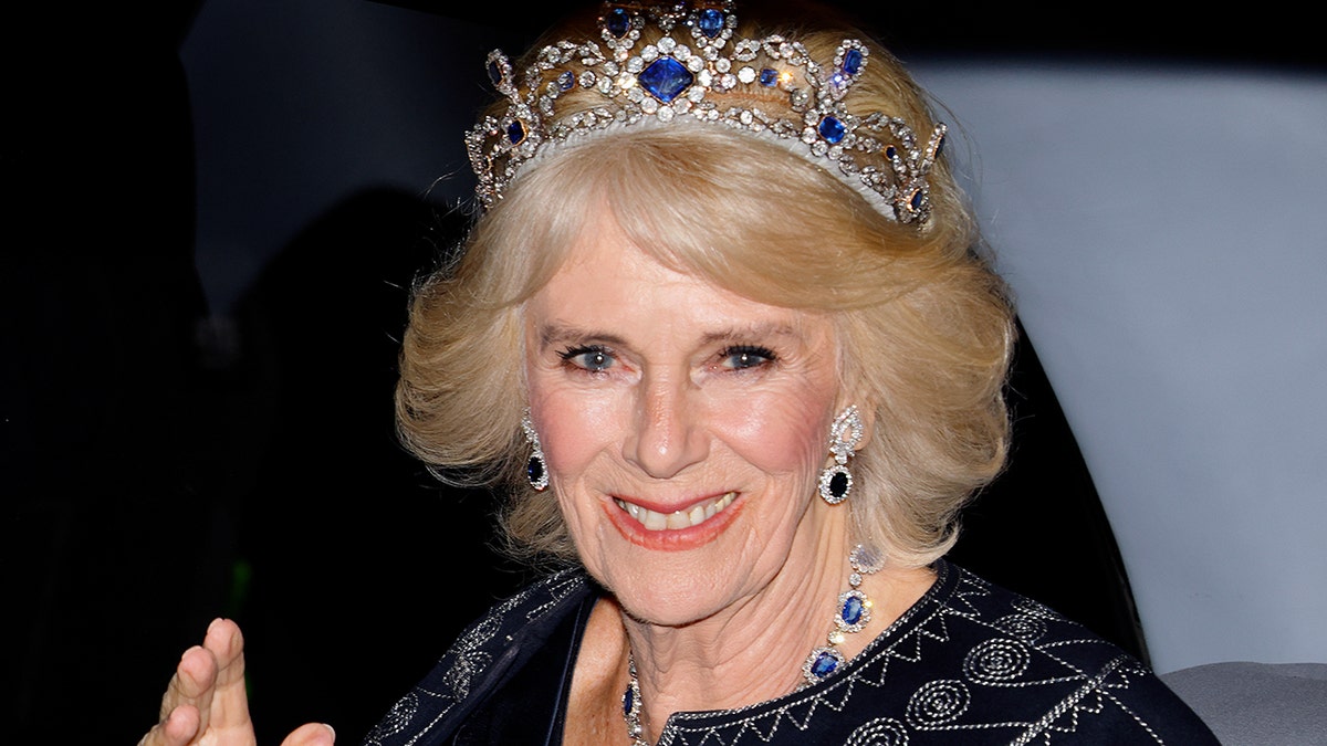 Camilla, Queen Consort smiling from her car wearing a tiara