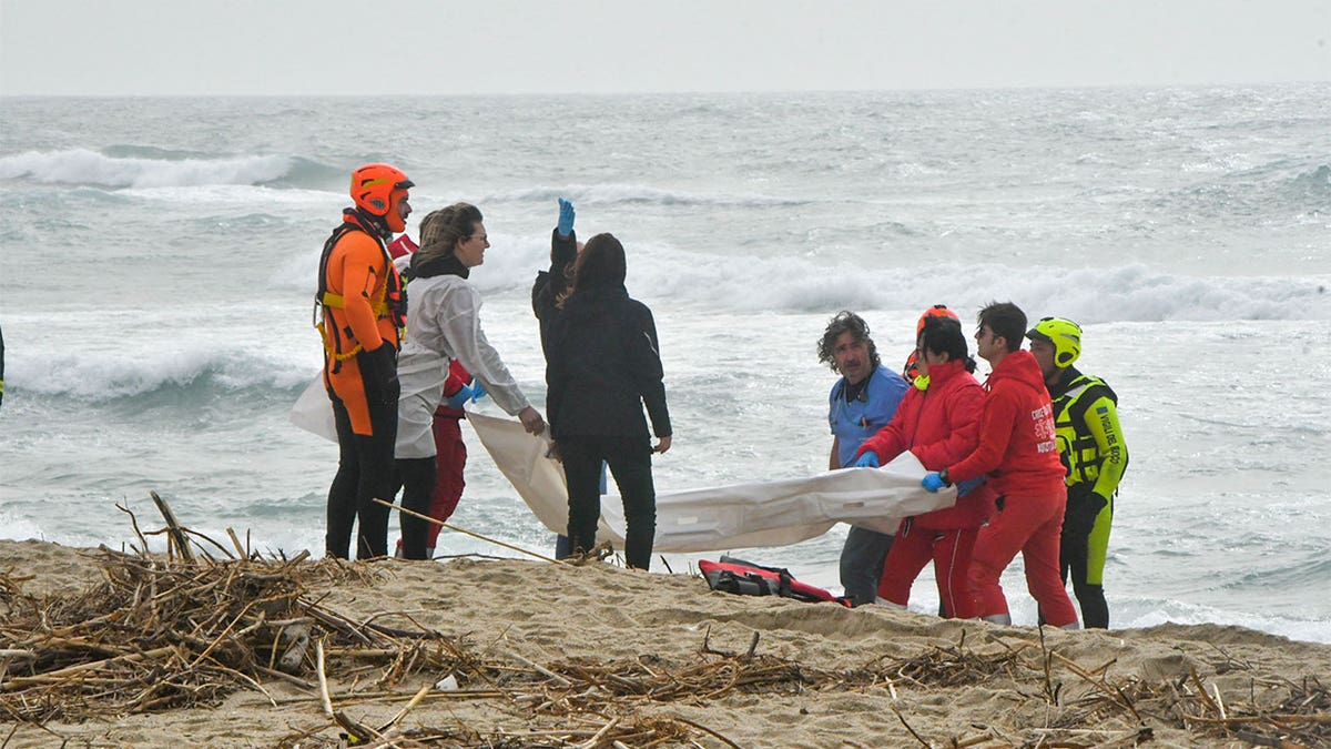 Rescuers recovering bodies from the beach.