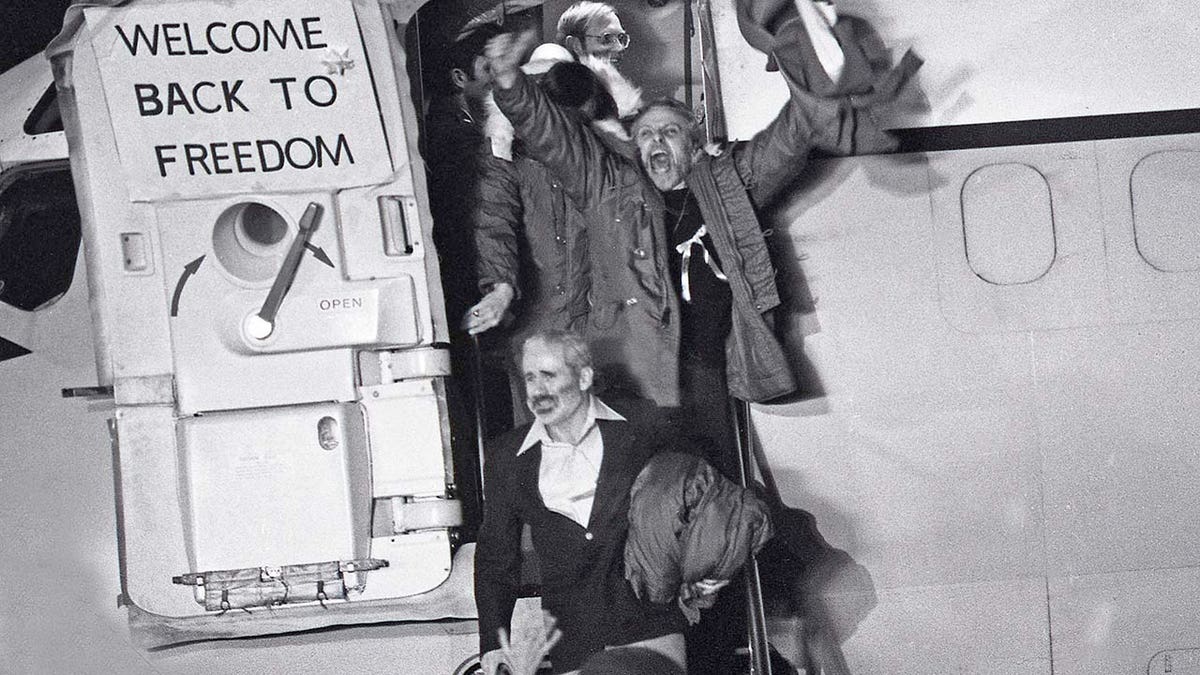 A group of men emerge from an airplane.