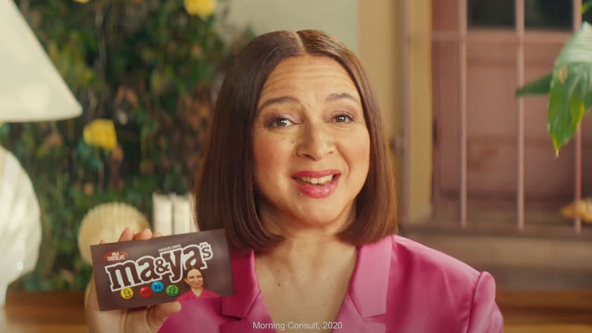 Maya Rudolph holding up an M&M's package that says "Ma&Ya's".
