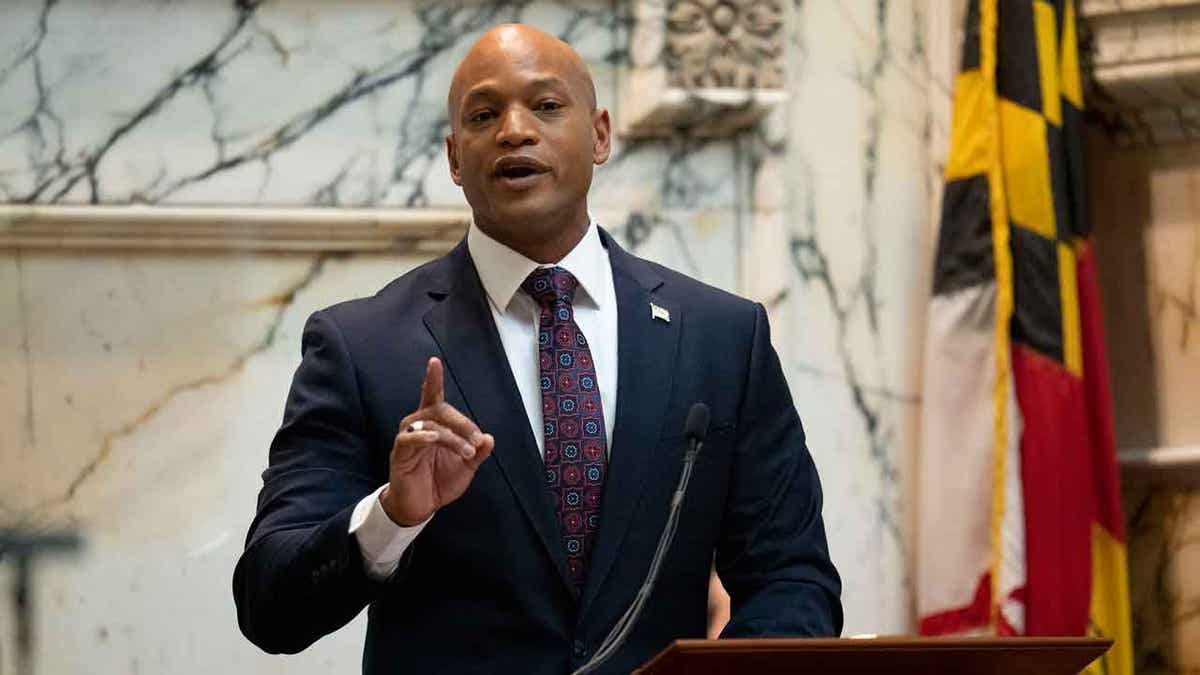 Gov. Wes Moore speaking with Maryland flag at right