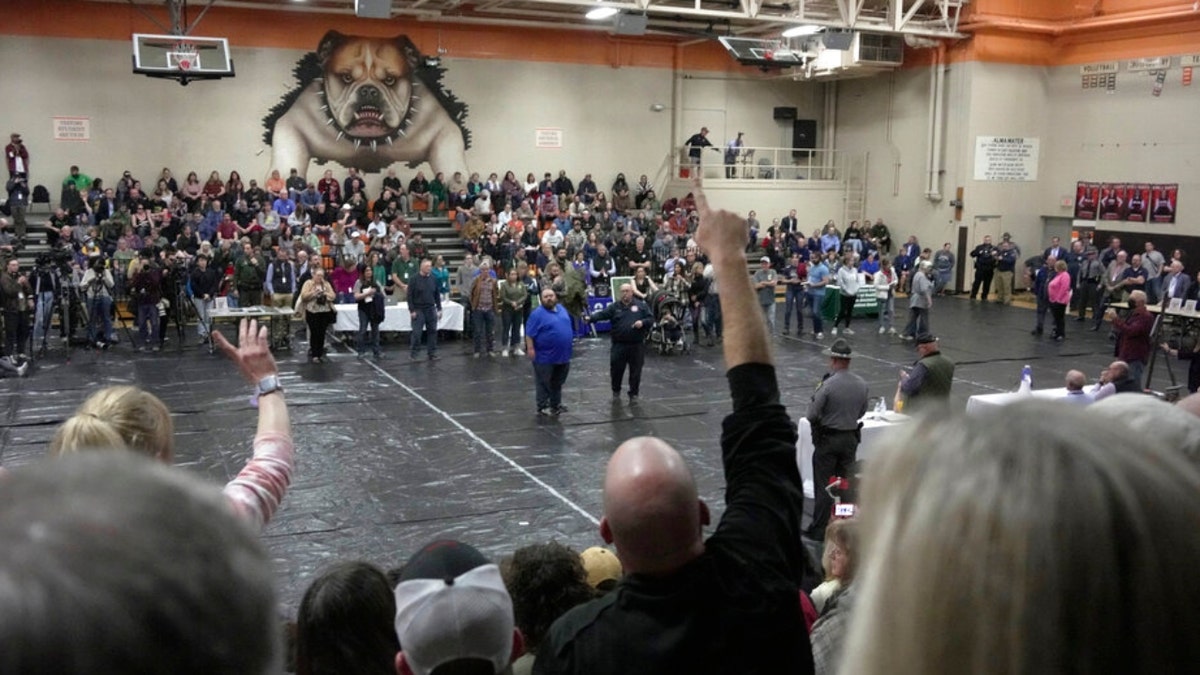 A man raises his hand with a question for East Palestine, Ohio, Mayor Trent Conaway