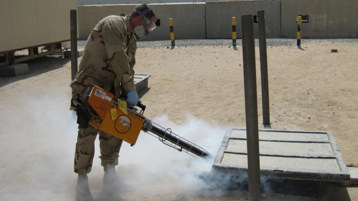 Navy Lt. Michael Fisher sprays mosquito repellent
