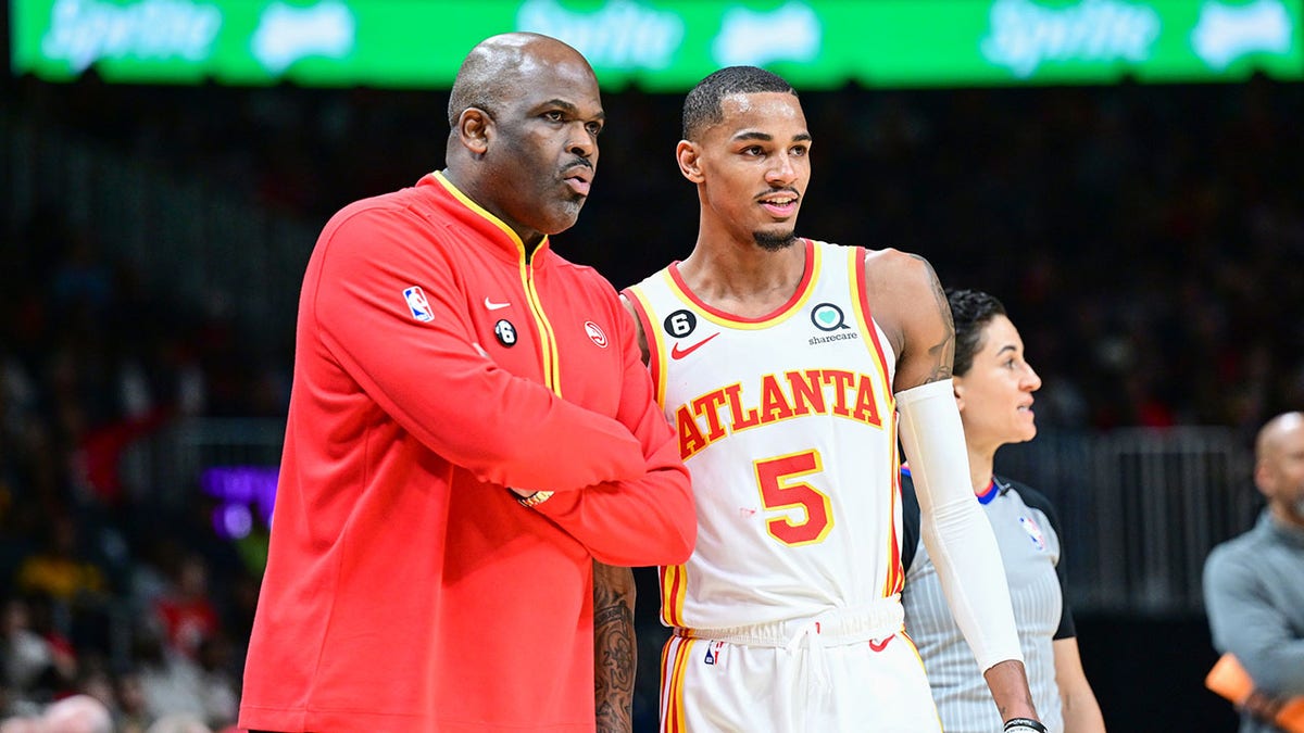 Nate McMillan and Dejounte Murray on the sidelines during a game