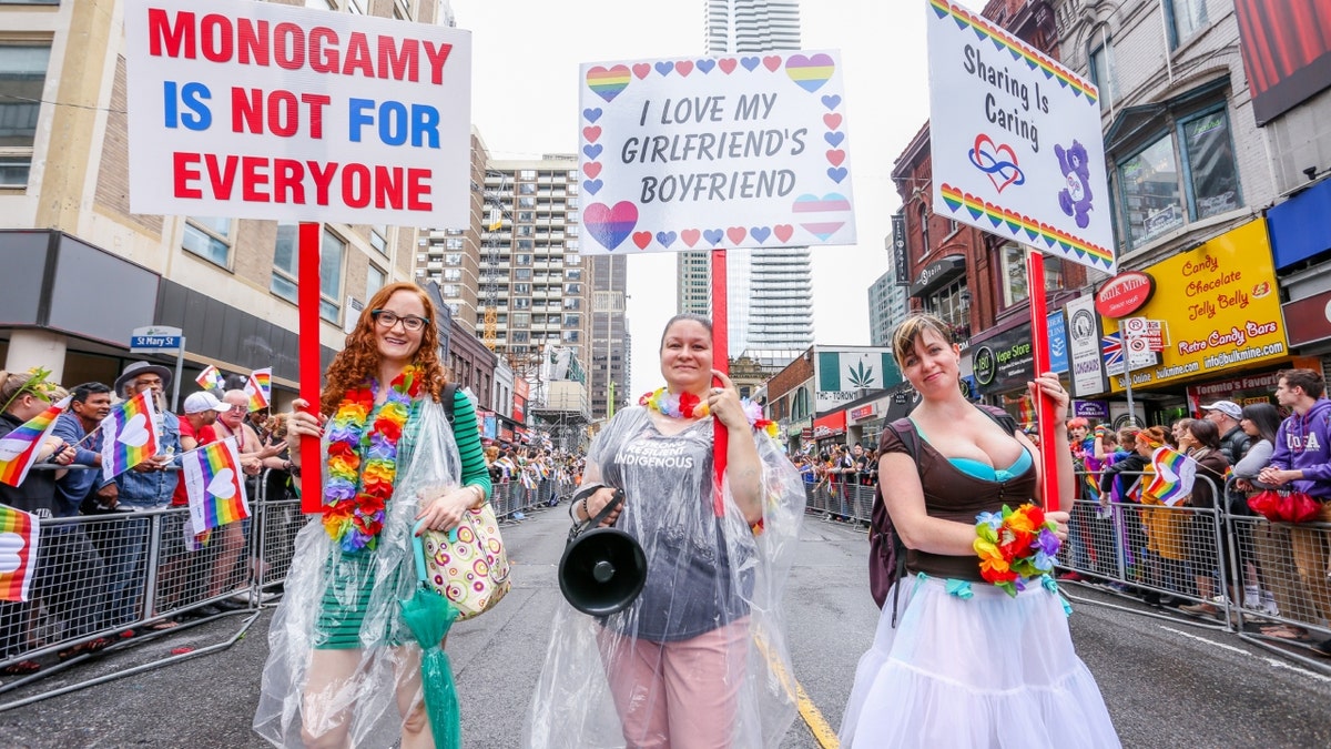 Polyamory group at 2018 pride parade holding signs