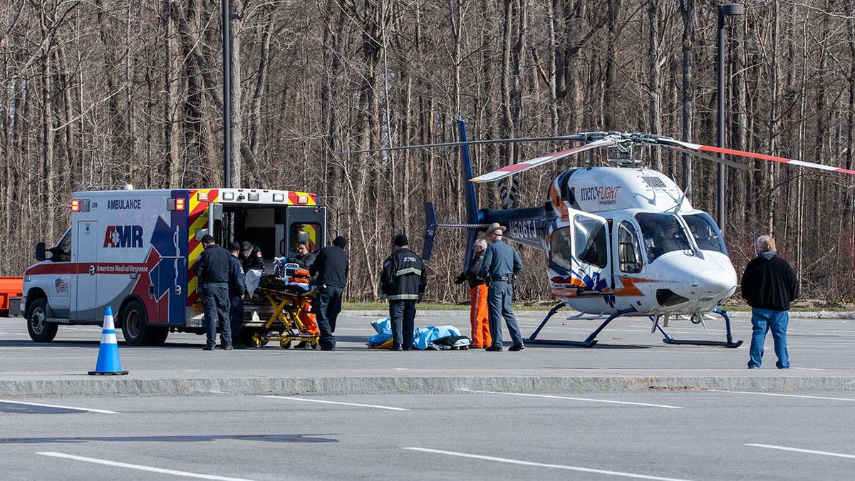 Emergency responders lift a person into a helicopter.
