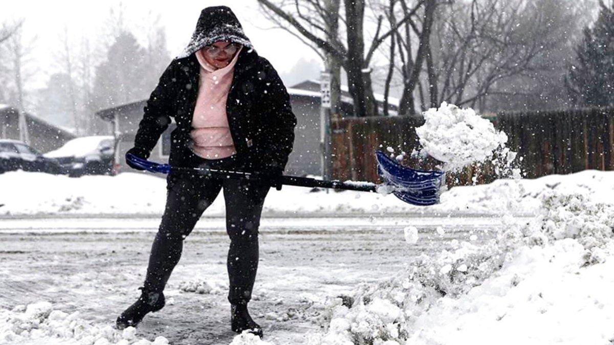 A woman clears chunks of snow in Arizona