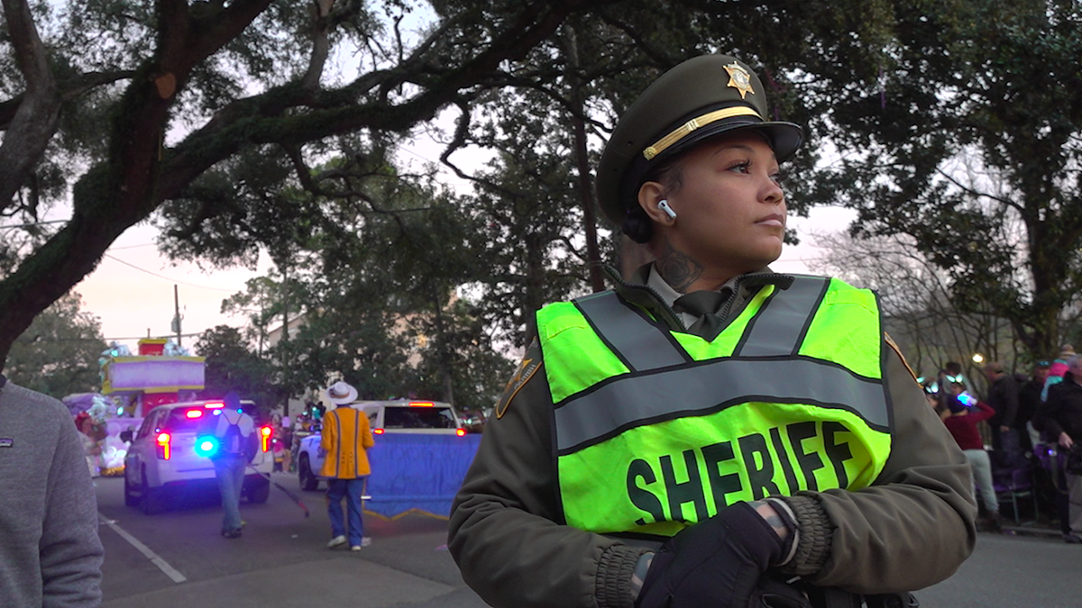 Mujer con uniforme de sheriff observando a la multitud en el desfile